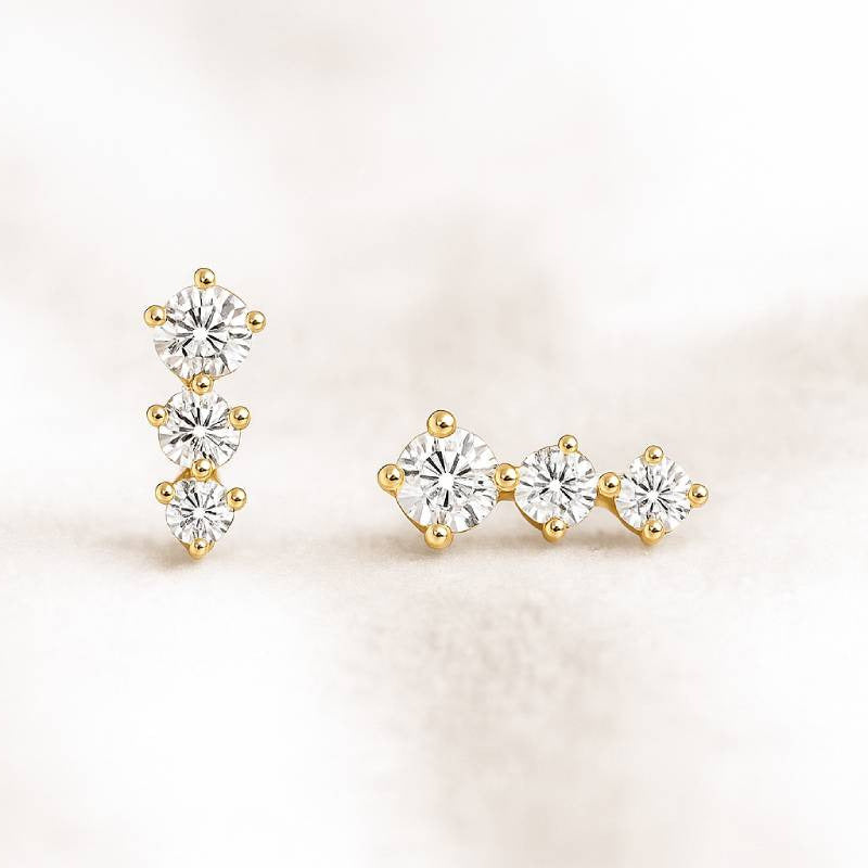 Pair of gold and diamond stud earrings on a light background