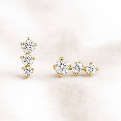 Pair of gold and diamond stud earrings on a light background