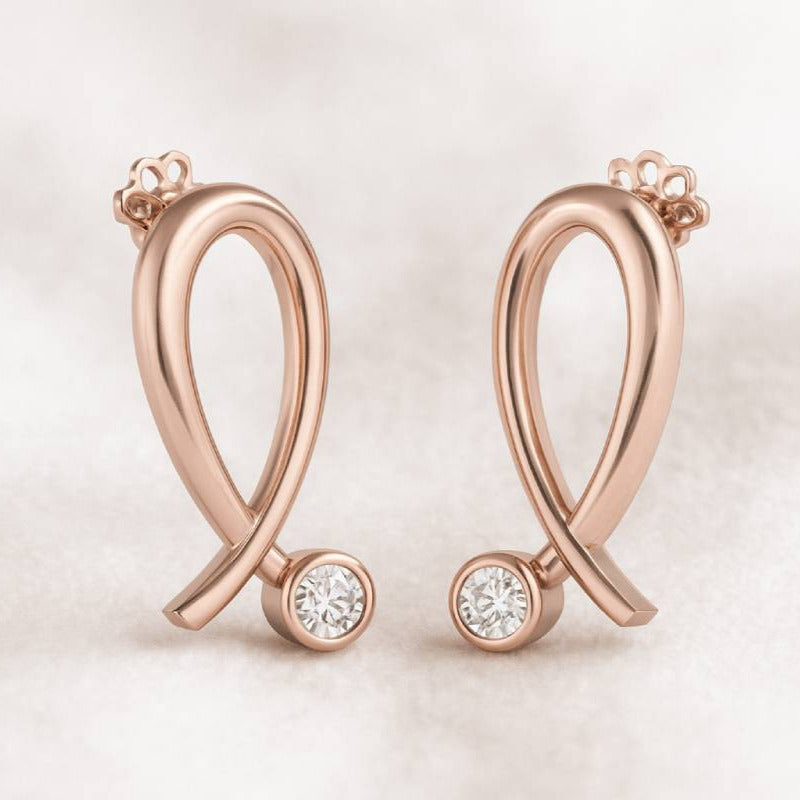 Rose gold earrings with diamond accents on a light background