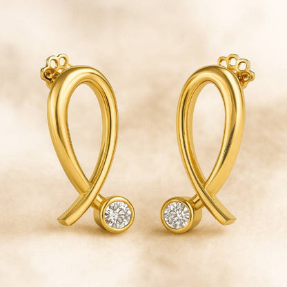Gold earrings with round gemstones on a beige background