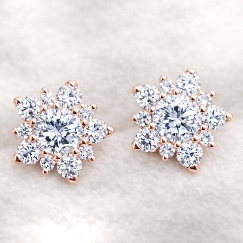 Rose gold and diamond earrings on a light background