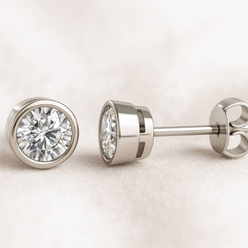 Pair of gold diamond stud earrings on a light background