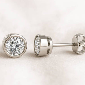 Pair of gold diamond stud earrings on a light background