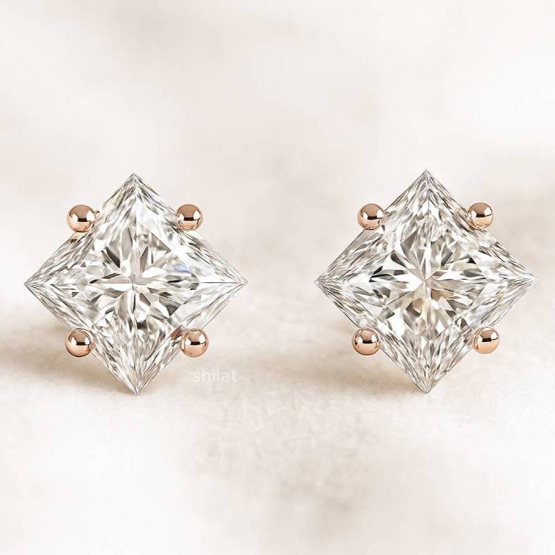 Pair of diamond stud earrings on a light background