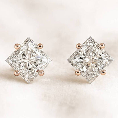 Pair of diamond stud earrings on a light background