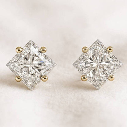 Pair of diamond stud earrings with gold accents on a light background