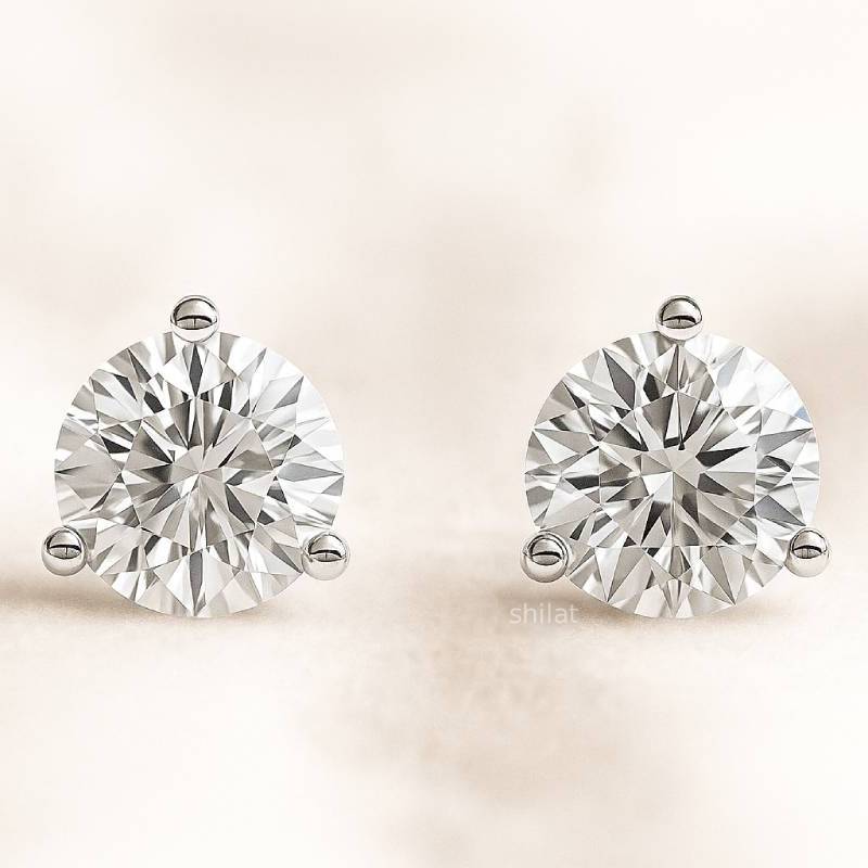 Pair of diamond earrings on a light beige background