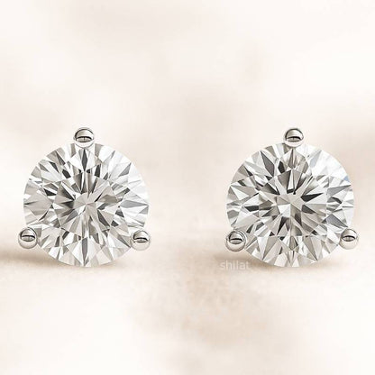 Pair of diamond earrings on a light beige background