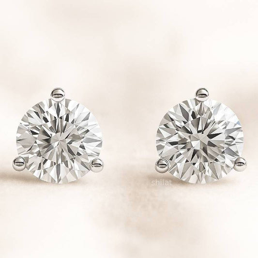 Pair of diamond earrings on a light beige background