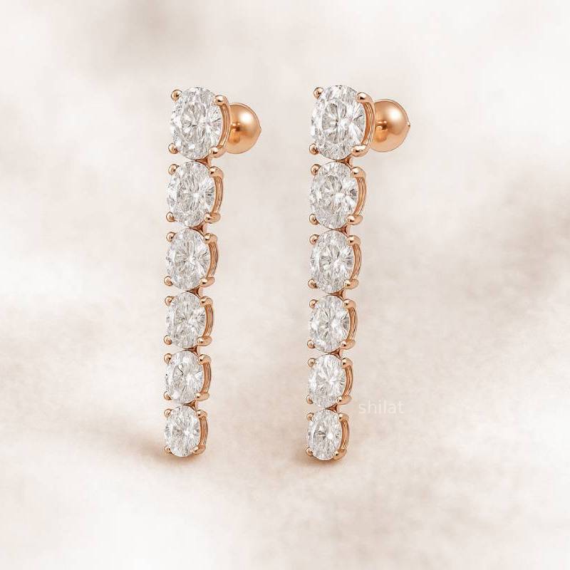 Rose gold earrings with clear gemstones on a soft beige background