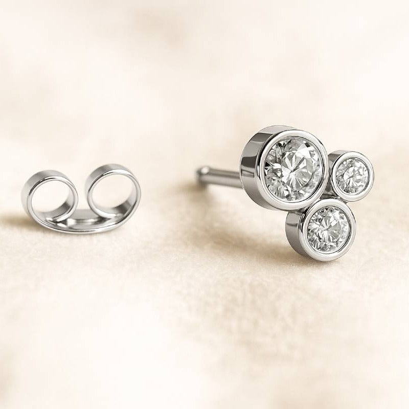 Diamond stud earrings on a beige background