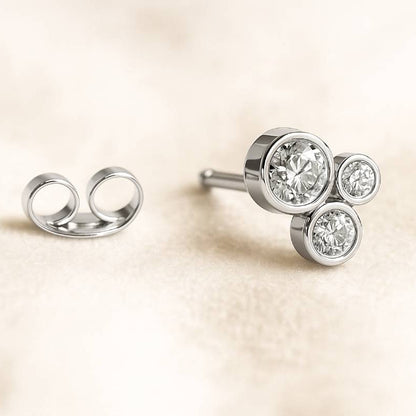 Diamond stud earrings on a beige background