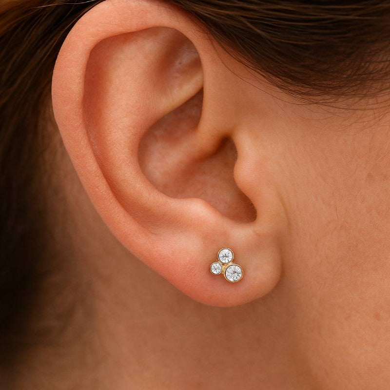 Close-up of an ear wearing a diamond stud earring.