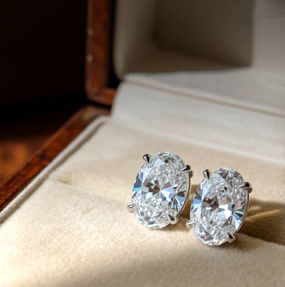 Pair of diamond earrings on a soft fabric surface