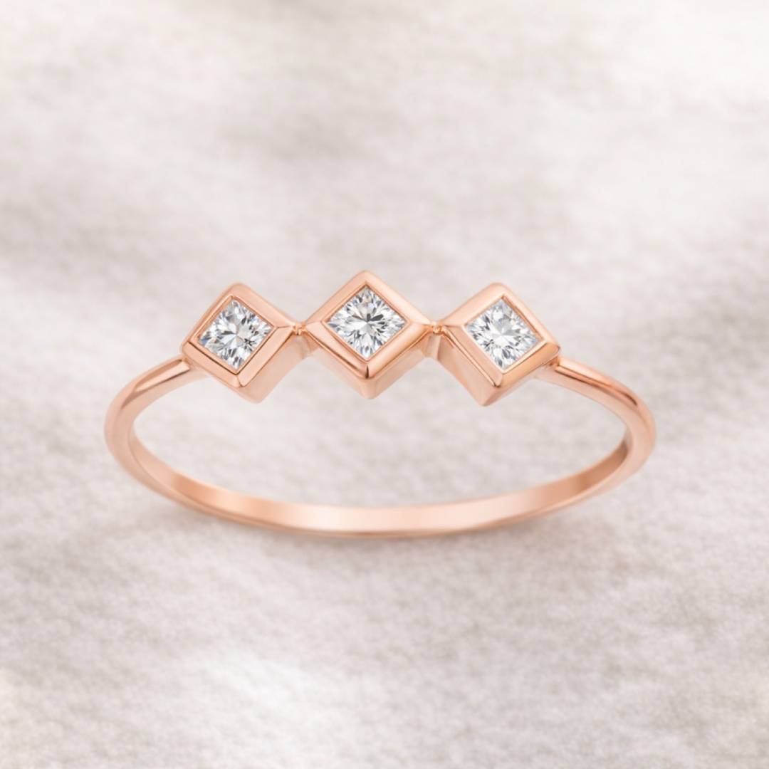 Rose gold ring with three diamonds on a light background