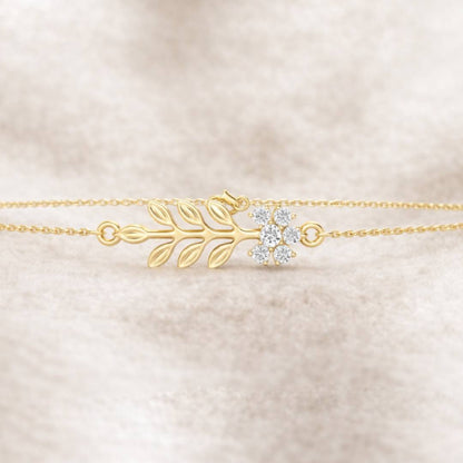 Gold bracelet with floral design on a beige fabric background