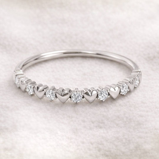 ring with heart and diamond designs on a light gray background