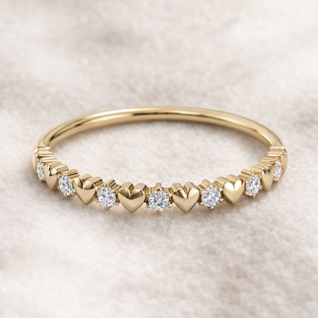 Gold ring with heart-shaped diamonds on a soft beige background