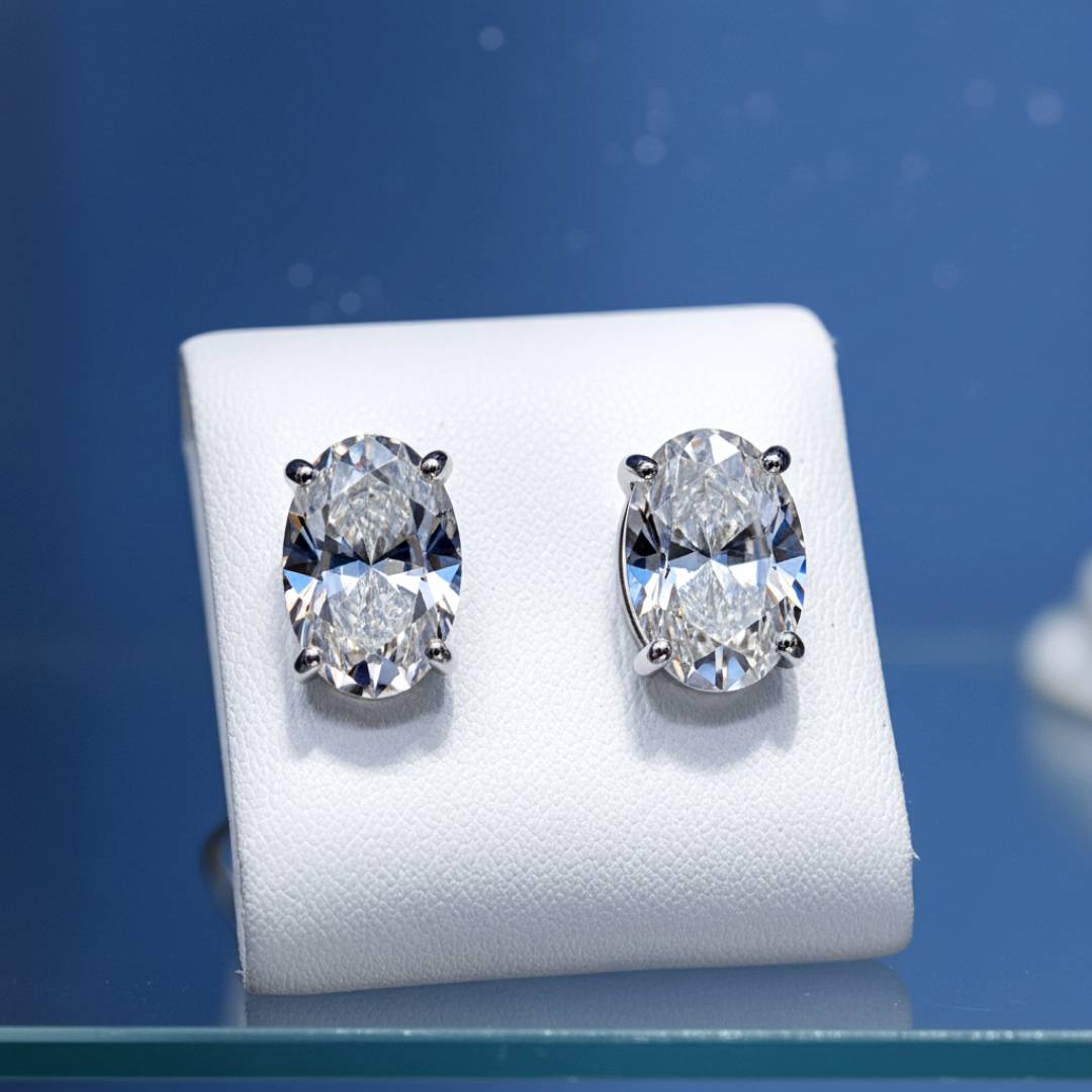 Diamond earrings on a white stand with a blue background