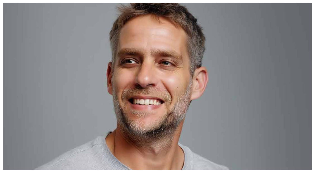hagai smiling against a gray background
