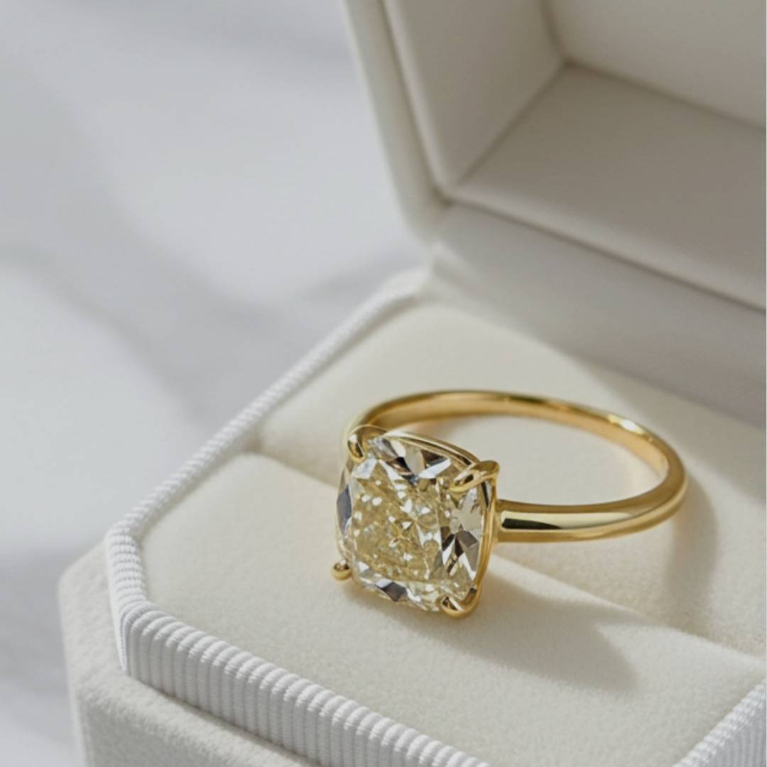 Gold ring with a large diamond in a jewelry box on a light background