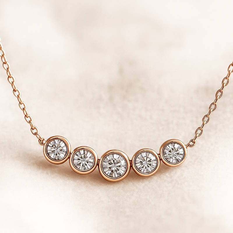 Rose gold necklace with five diamond beads on a beige background