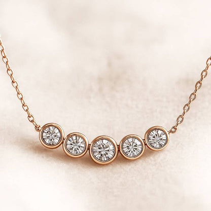 Rose gold necklace with five diamond beads on a beige background