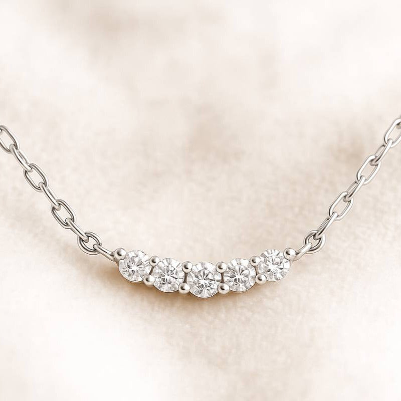 necklace with small diamonds on a light pink background