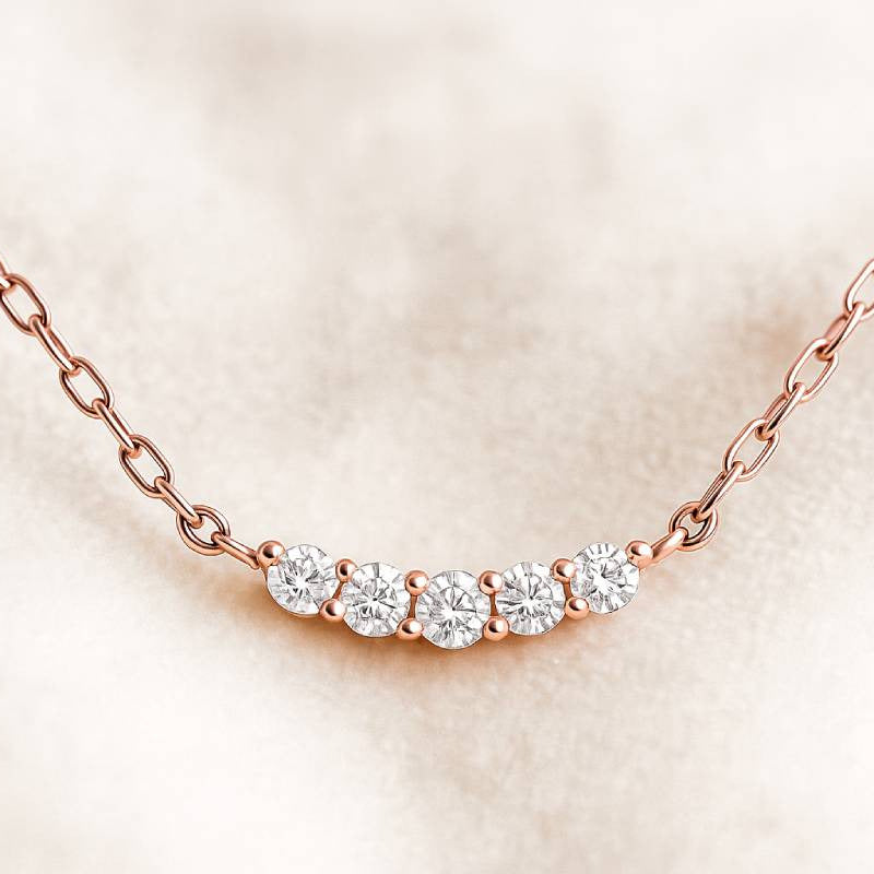 Rose gold necklace with diamonds on a beige background