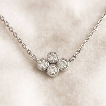 necklace with four round diamonds on a light background