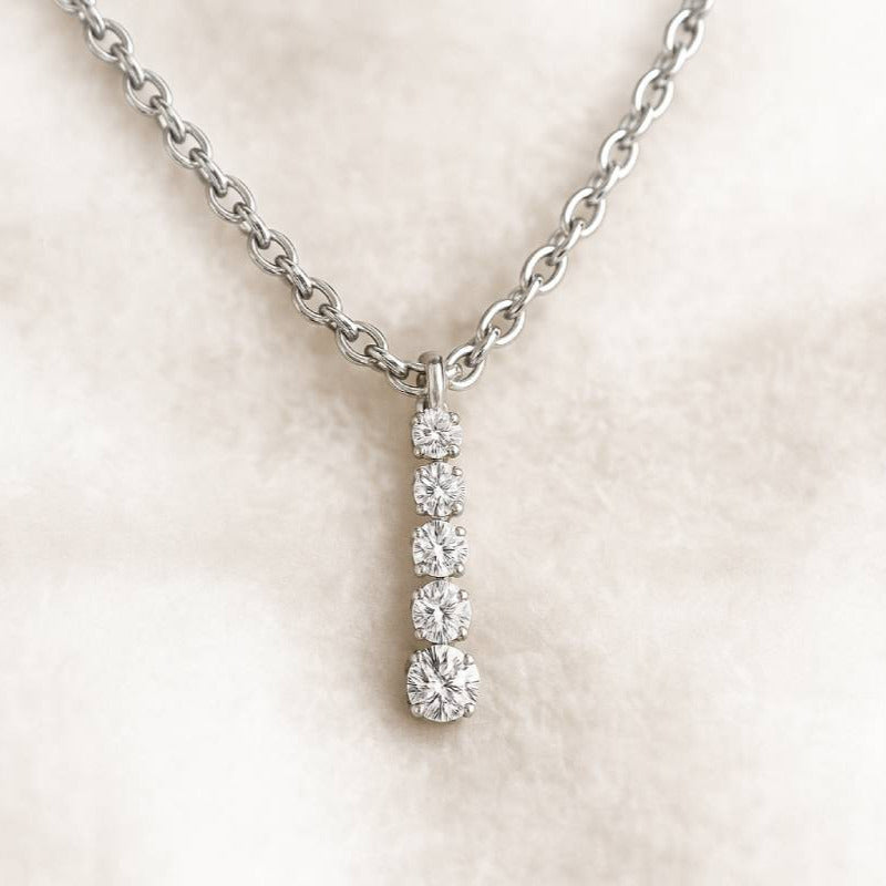 Diamond pendant necklace on a light beige background
