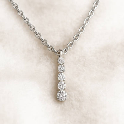 Diamond pendant necklace on a light beige background