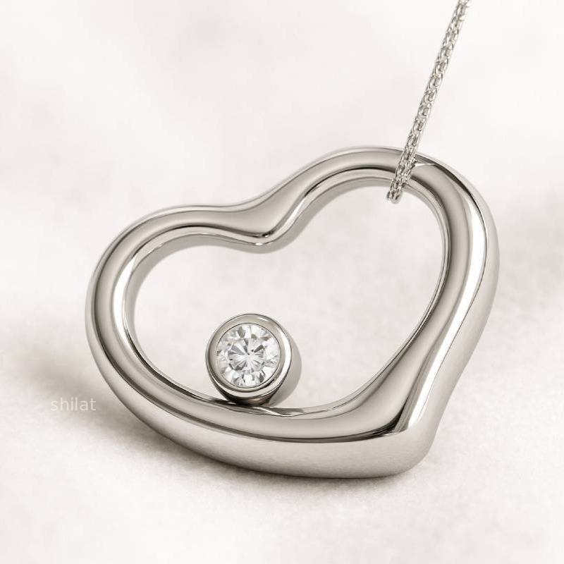 Silver heart-shaped pendant with a diamond on a light background