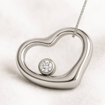 Silver heart-shaped pendant with a diamond on a light background