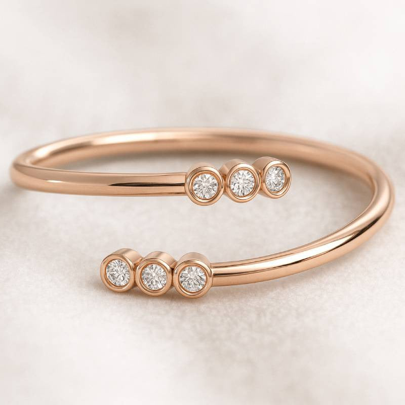 Rose gold bracelet with embedded diamonds on a light background