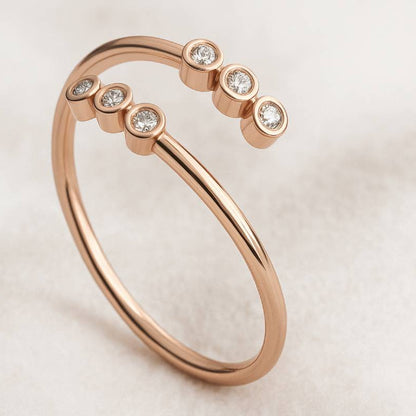 Rose gold ring with small diamonds on a light background