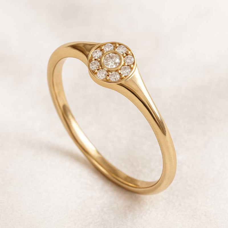 Gold ring with diamond accents on a light background