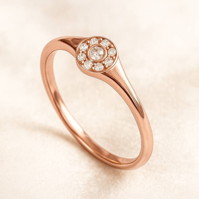 Rose gold ring with diamond accents on a beige background
