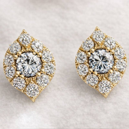 Pair of gold and diamond earrings on a light background
