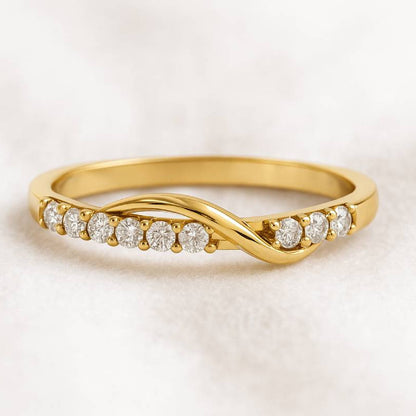 Gold ring with diamonds on a light beige background