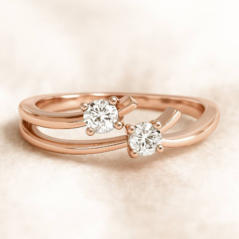 Rose gold ring with two diamond stones on a beige background