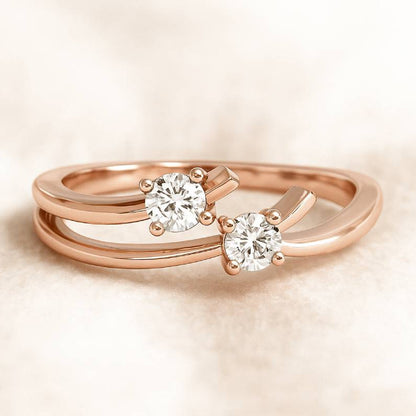 Rose gold ring with two diamond stones on a beige background
