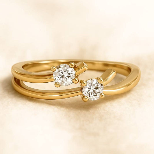 Gold ring with two diamonds on a beige background