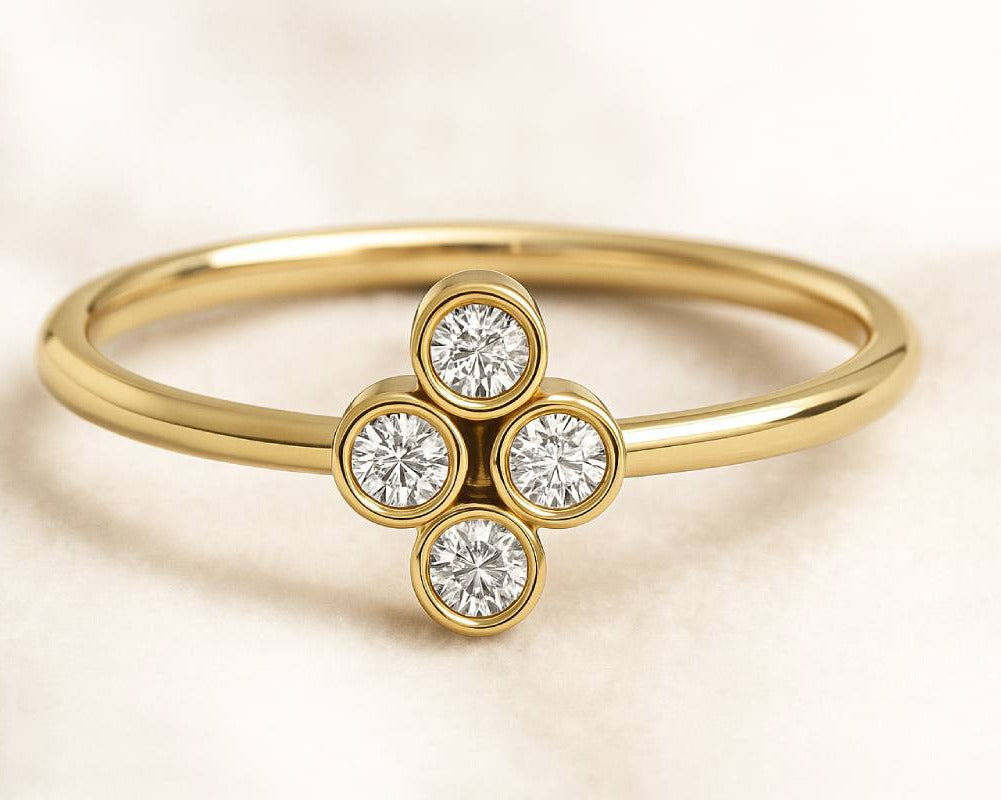 Gold ring with diamond quatrefoil design on a beige background