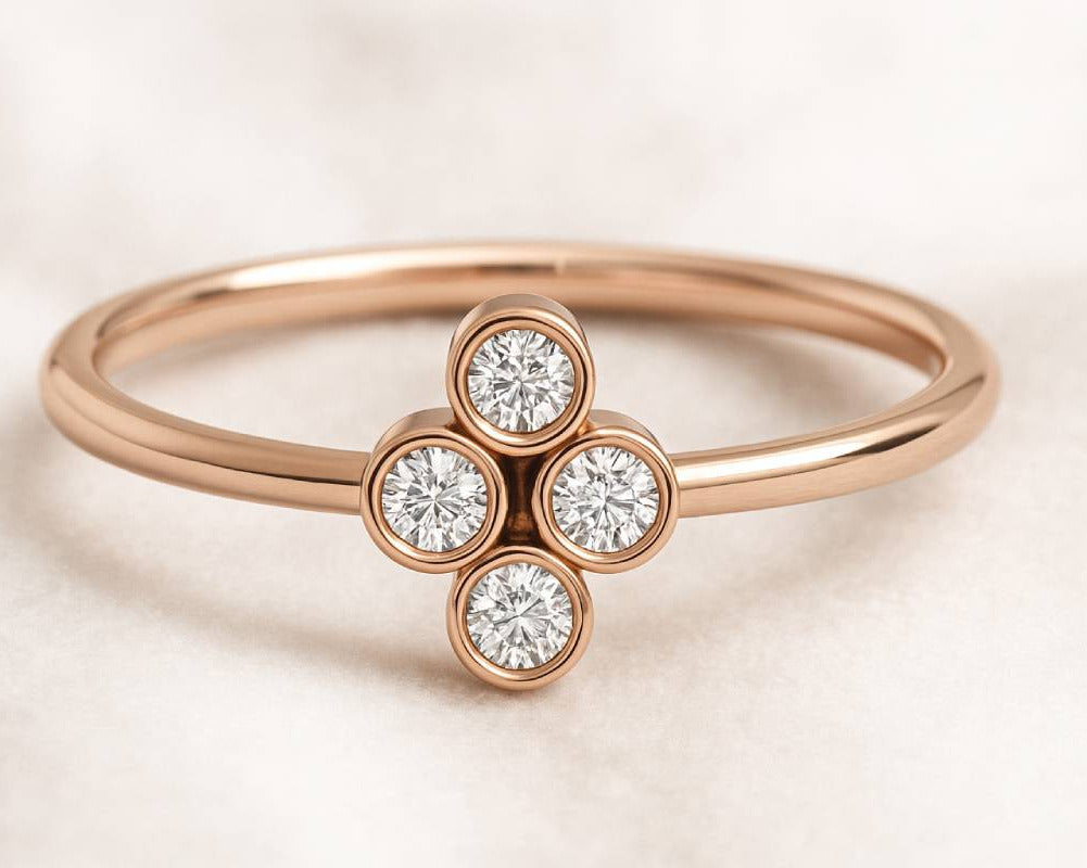 Rose gold ring with diamond flower design on a light background