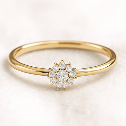 Gold ring with a diamond flower design on a light background