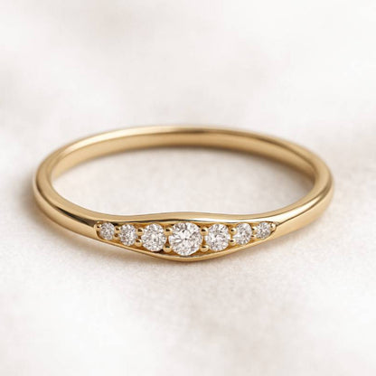 Gold ring with small diamonds on a light background