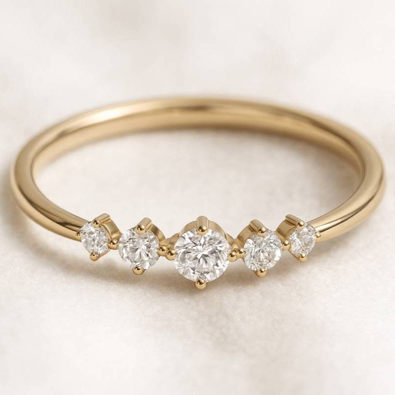 Gold ring with five diamonds on a light background