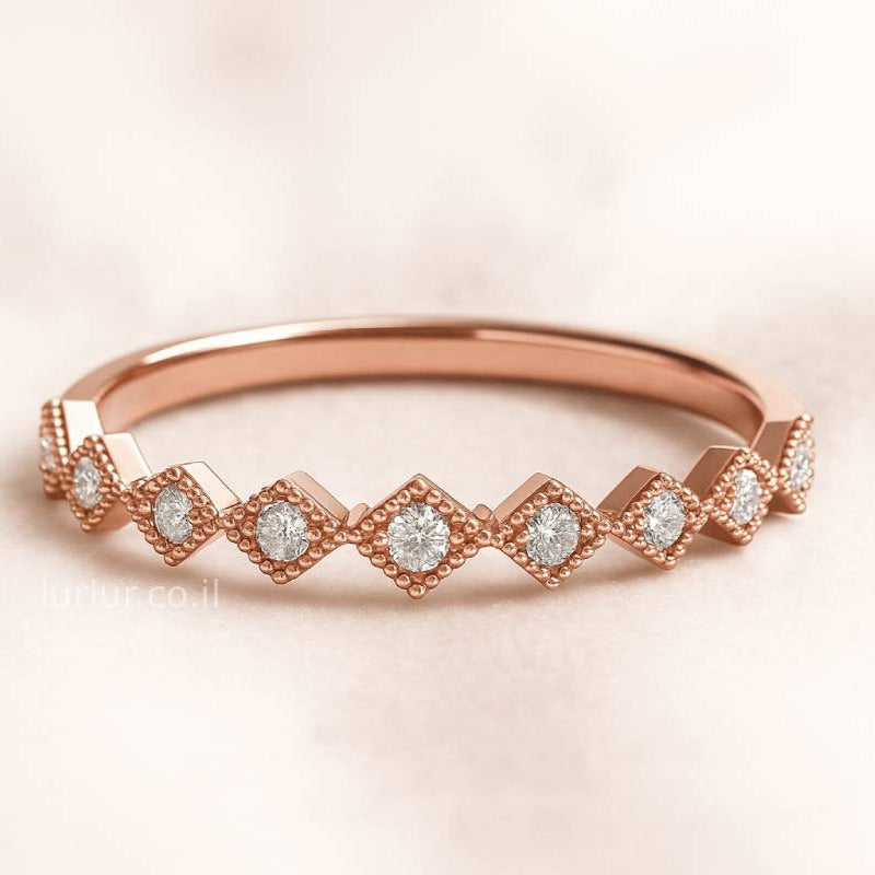 Rose gold ring with diamond accents on a light pink background