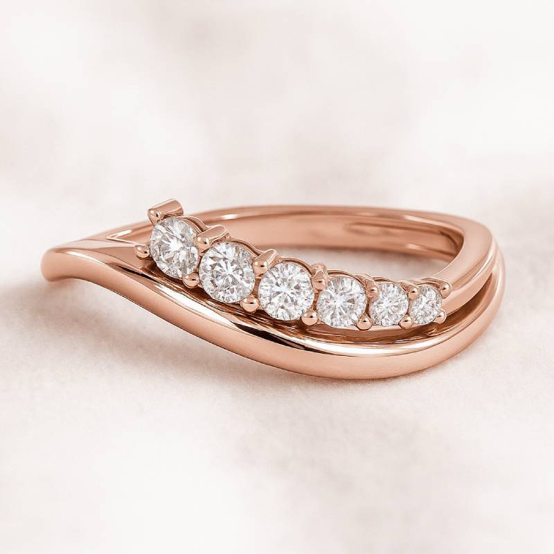 Rose gold ring with diamonds on a light pink background